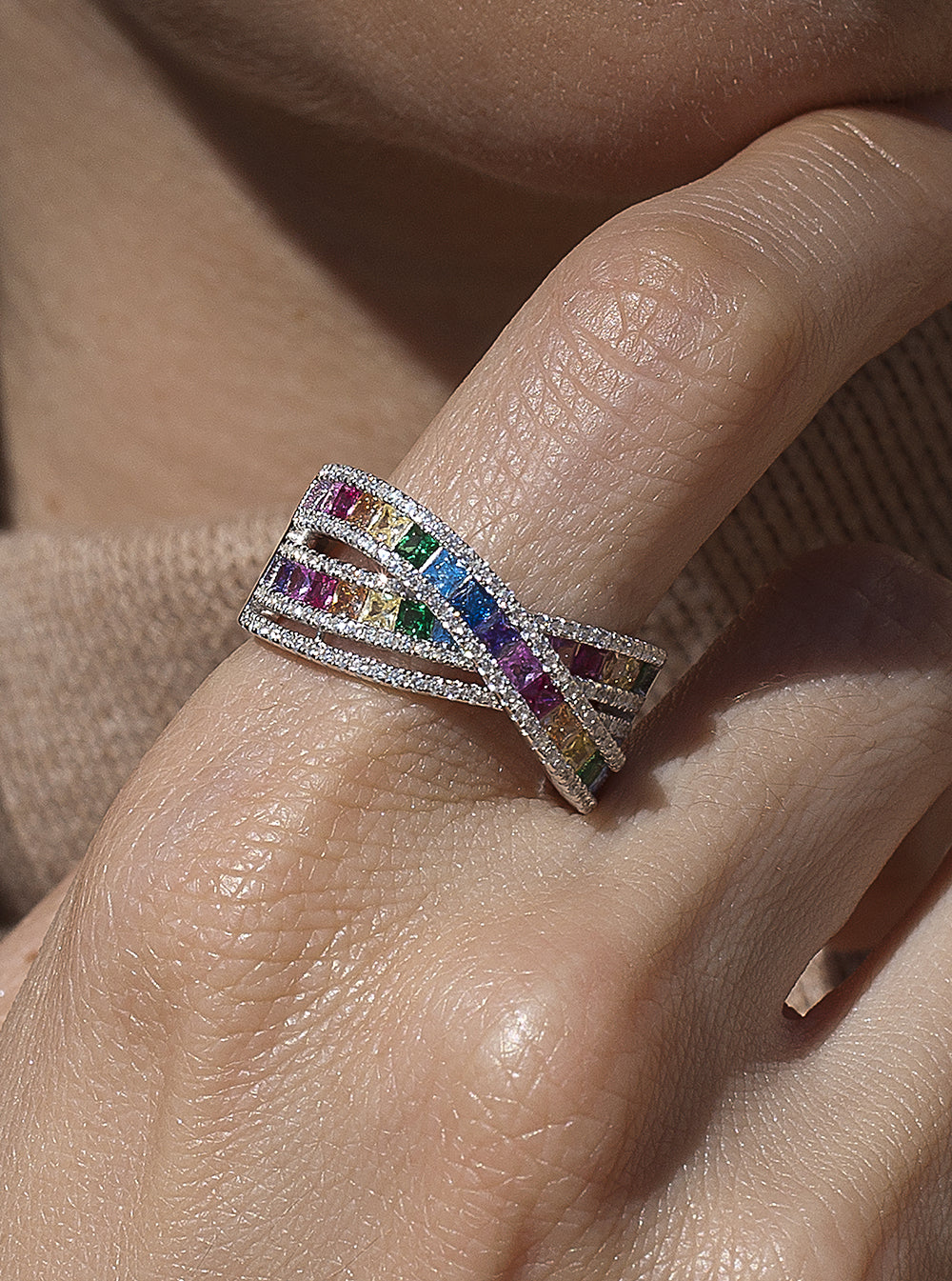 Ring with multicolored crossed rail design stones