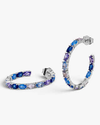 Boucles d'oreilles créoles ornées de pierres ovales dans des tons de bleu.
