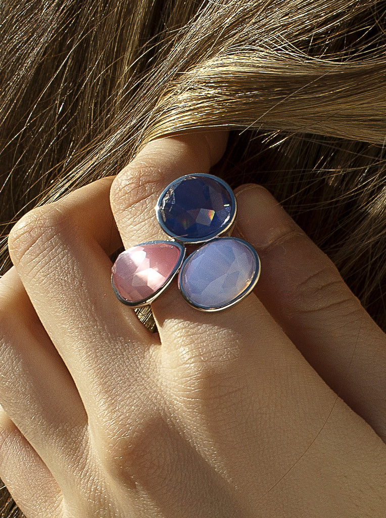 Anillo de plata con tres piedras facetadas en tonos violetas y rosa