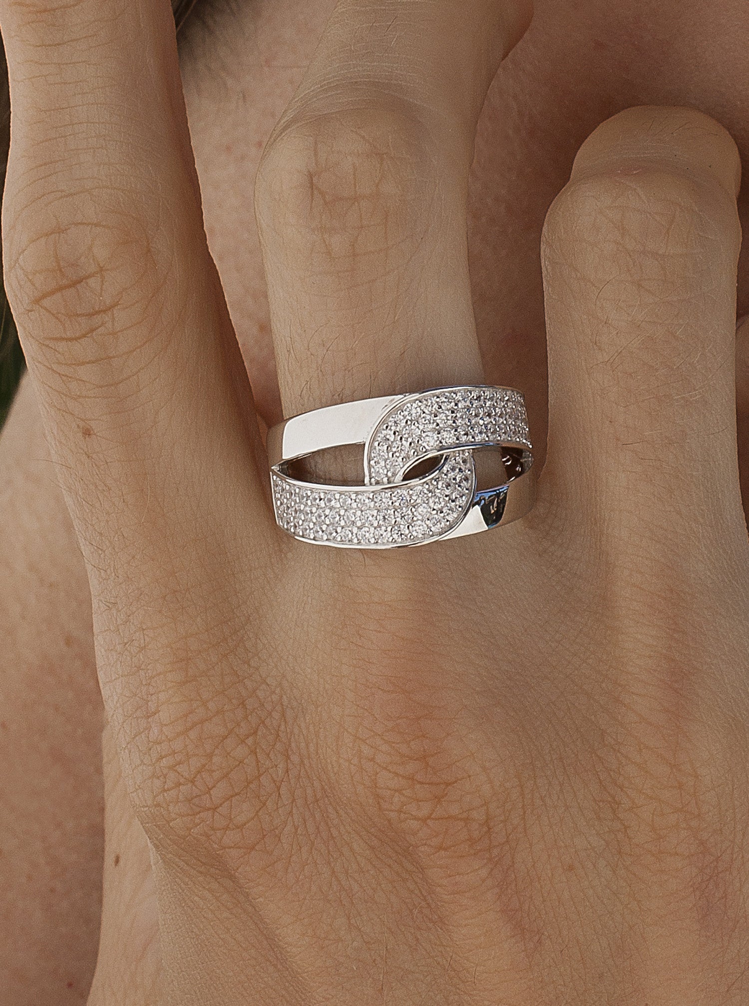 Anillo grande entrelazado con circonitas