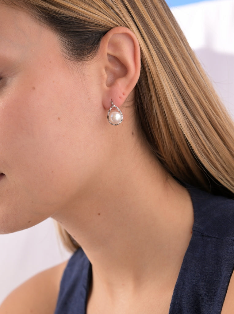 Boucles d'oreilles pendantes en perles ornées d'un zircon.