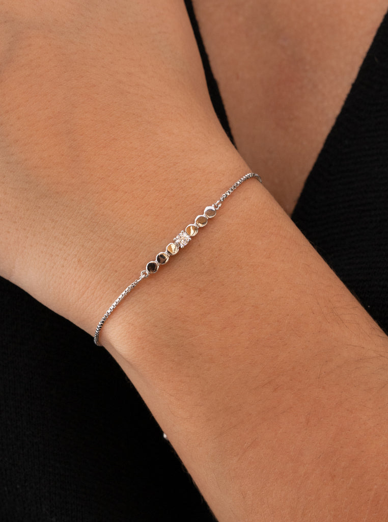 Pulsera fina de plata con piezas circulares y circonita central