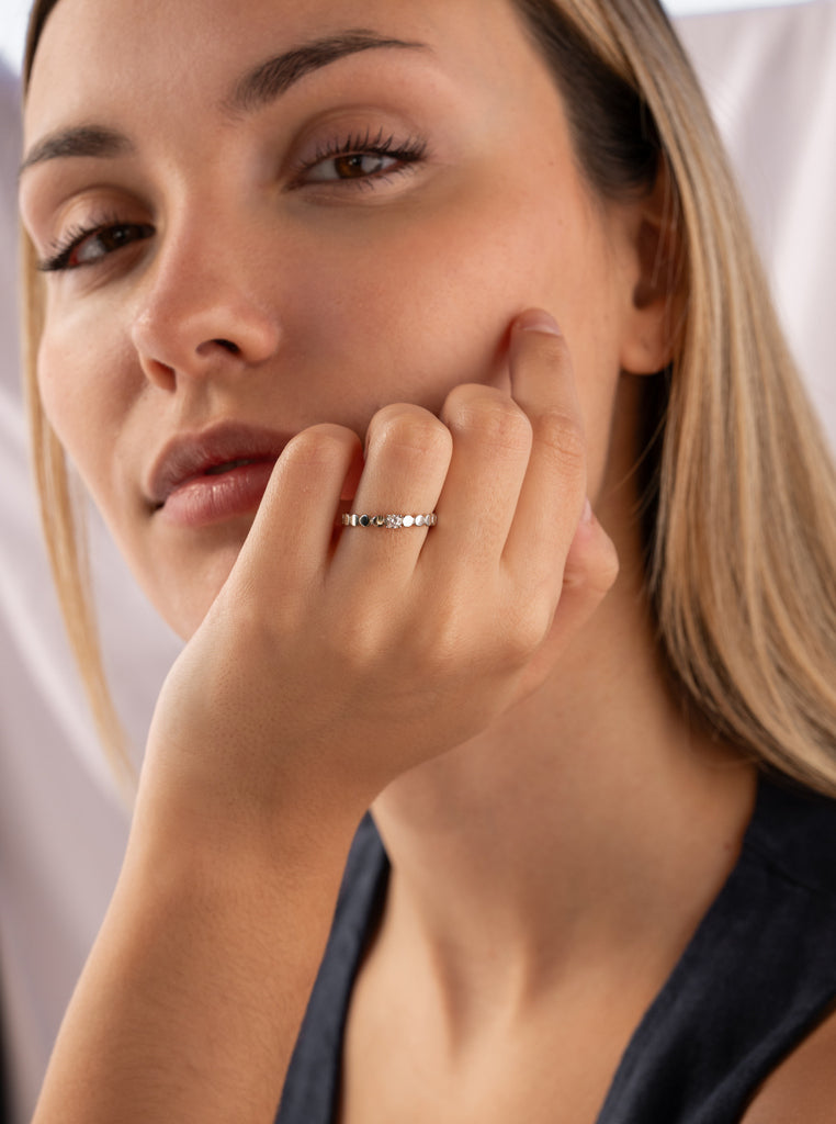 Anillo fino de plata con piezas circulares y circonita central