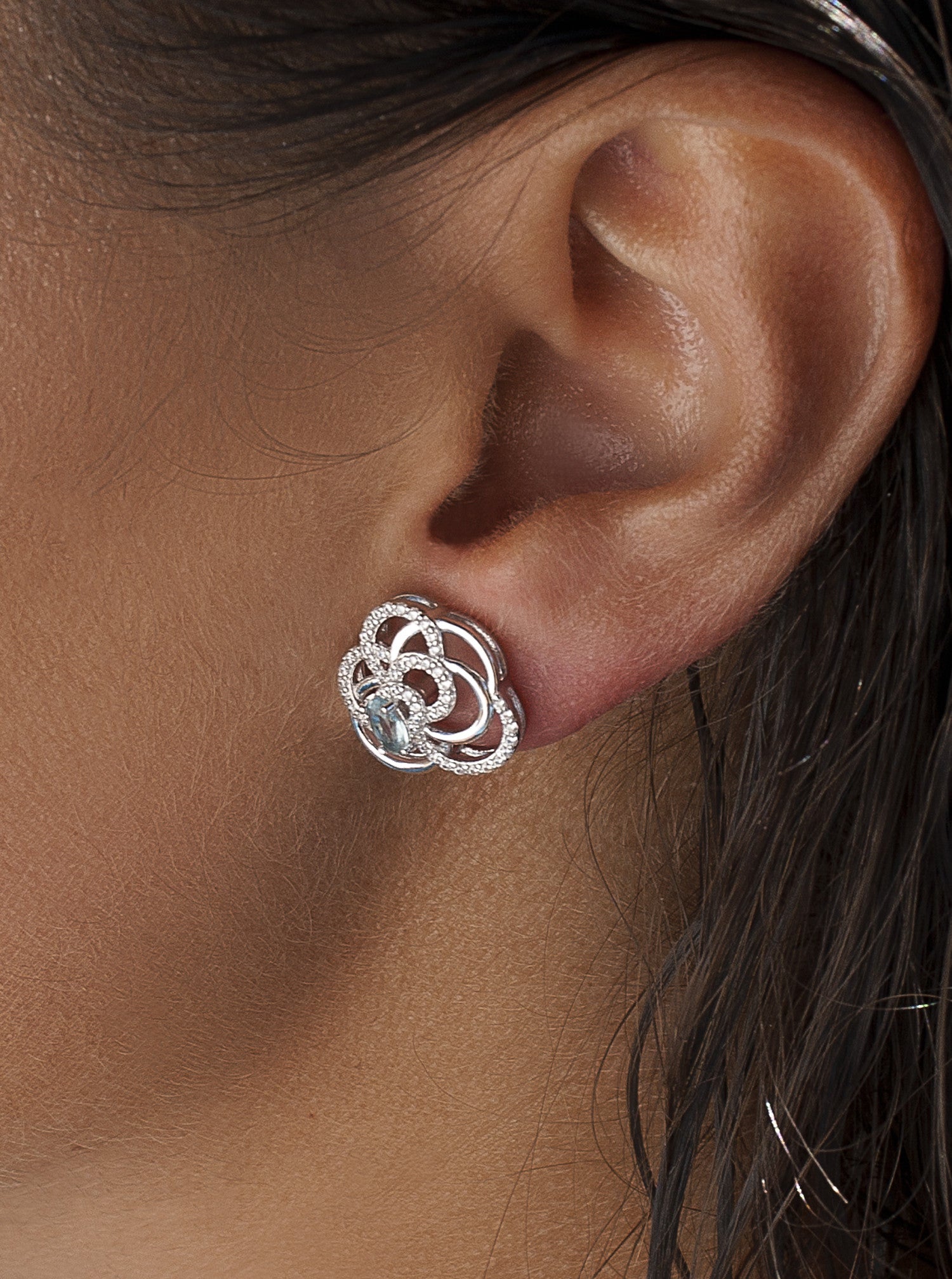 Silver earrings intertwined with aqua-toned cubic zirconia