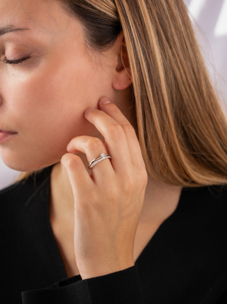 Delicate ring with double cubic zirconia and central cubic zirconia.