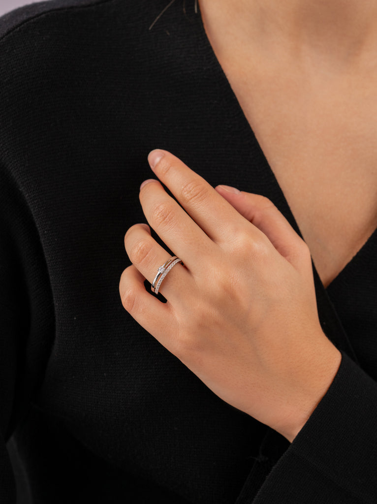 Delicate ring with double cubic zirconia and central cubic zirconia.
