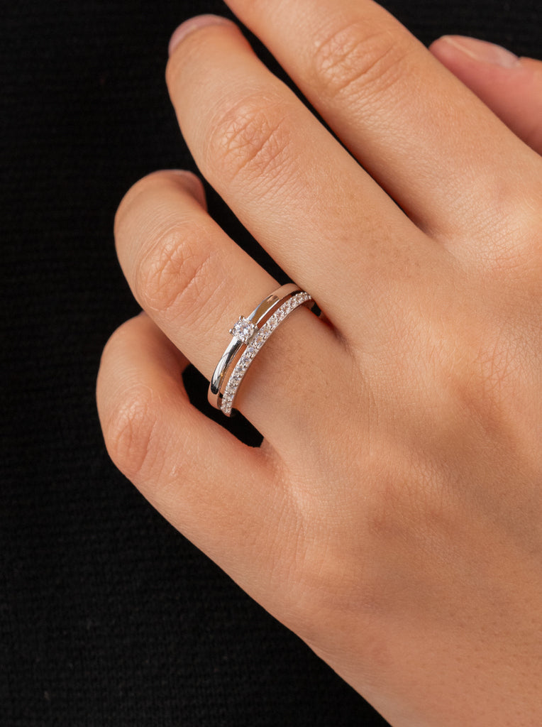 Delicate ring with double cubic zirconia and central cubic zirconia.