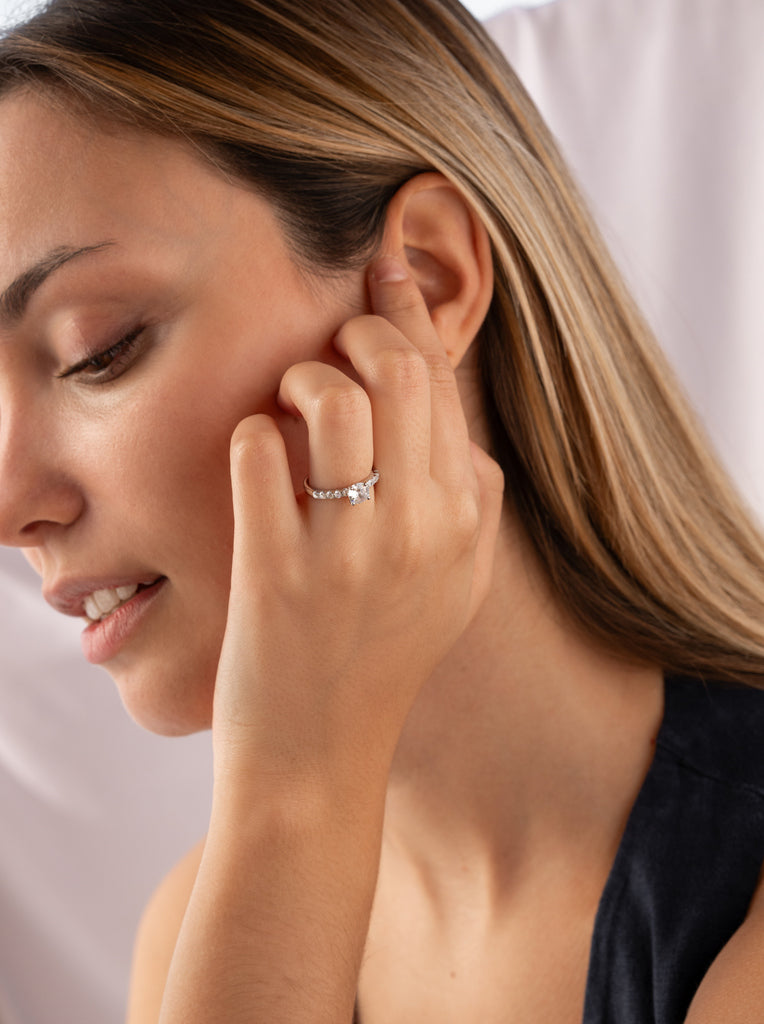 Anillo solitario con circonitas en el contorno de plata