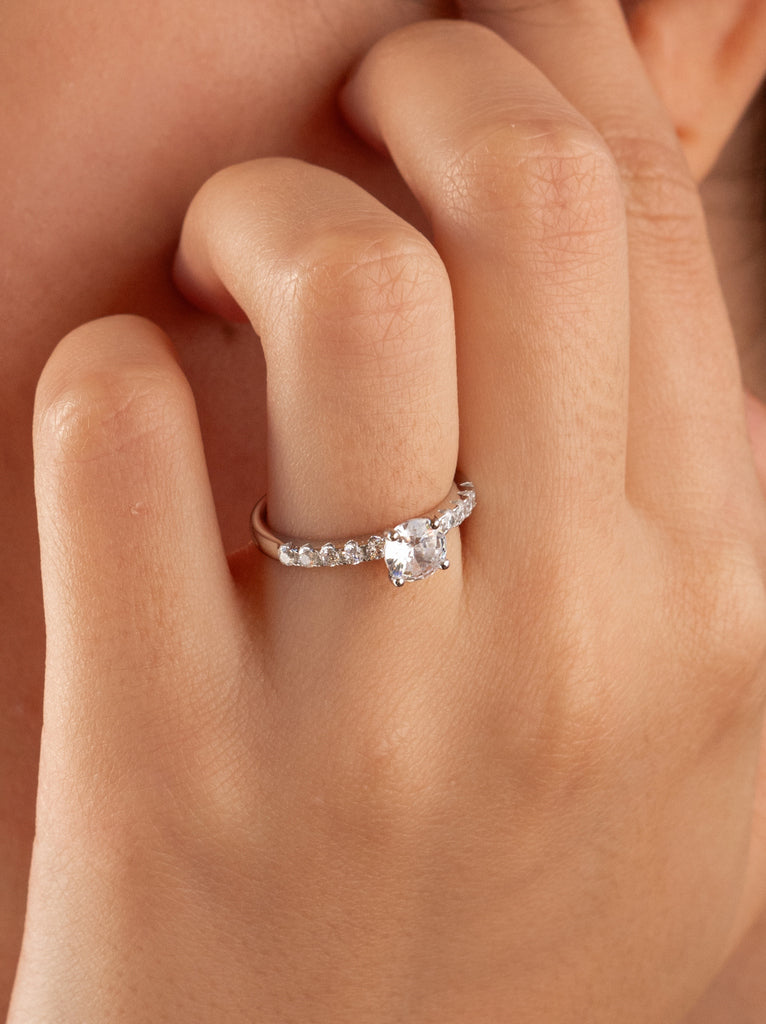 Anillo solitario con circonitas en el contorno de plata