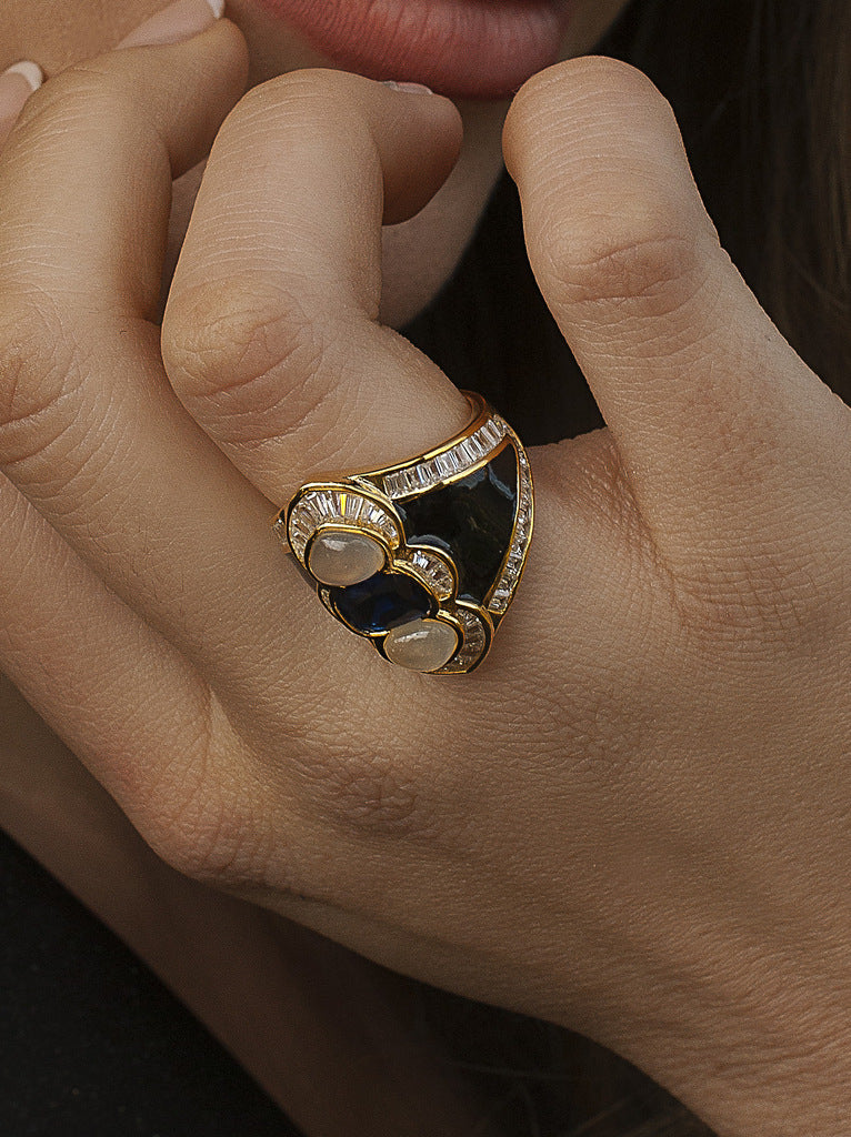 Anillo de plata dorado con esmalte negro piedra azul y circonitas