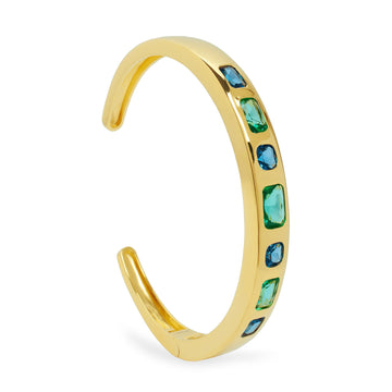 Pulsera de plata dorada rígida abierta con piedras verdes y azules tipo baguette