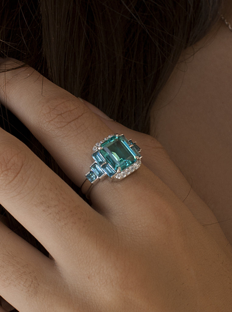 Anillo de plata con piedra verde y baguettes azul cielo