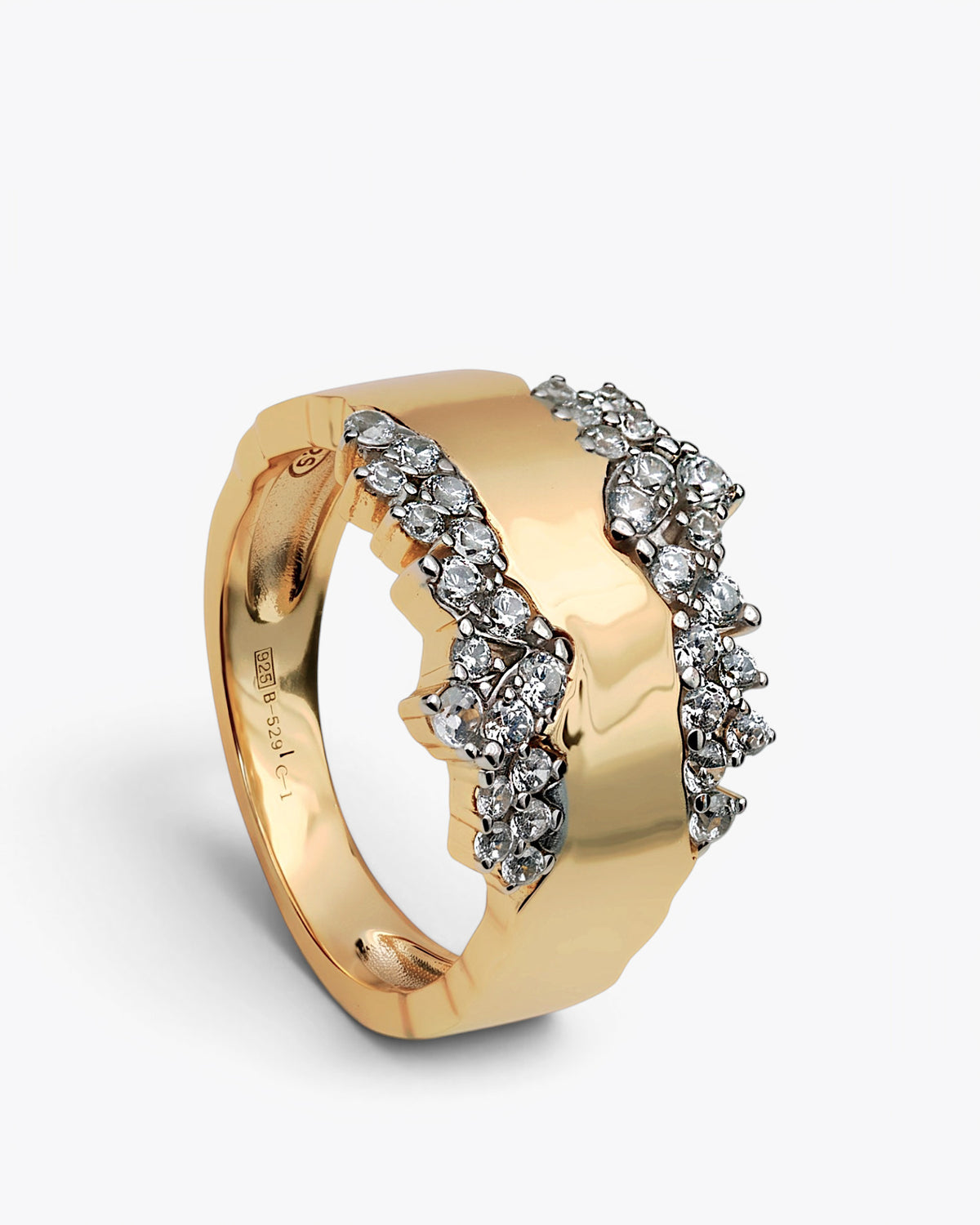 Anillo ancho dorado con banda ondulada y piedras blancas