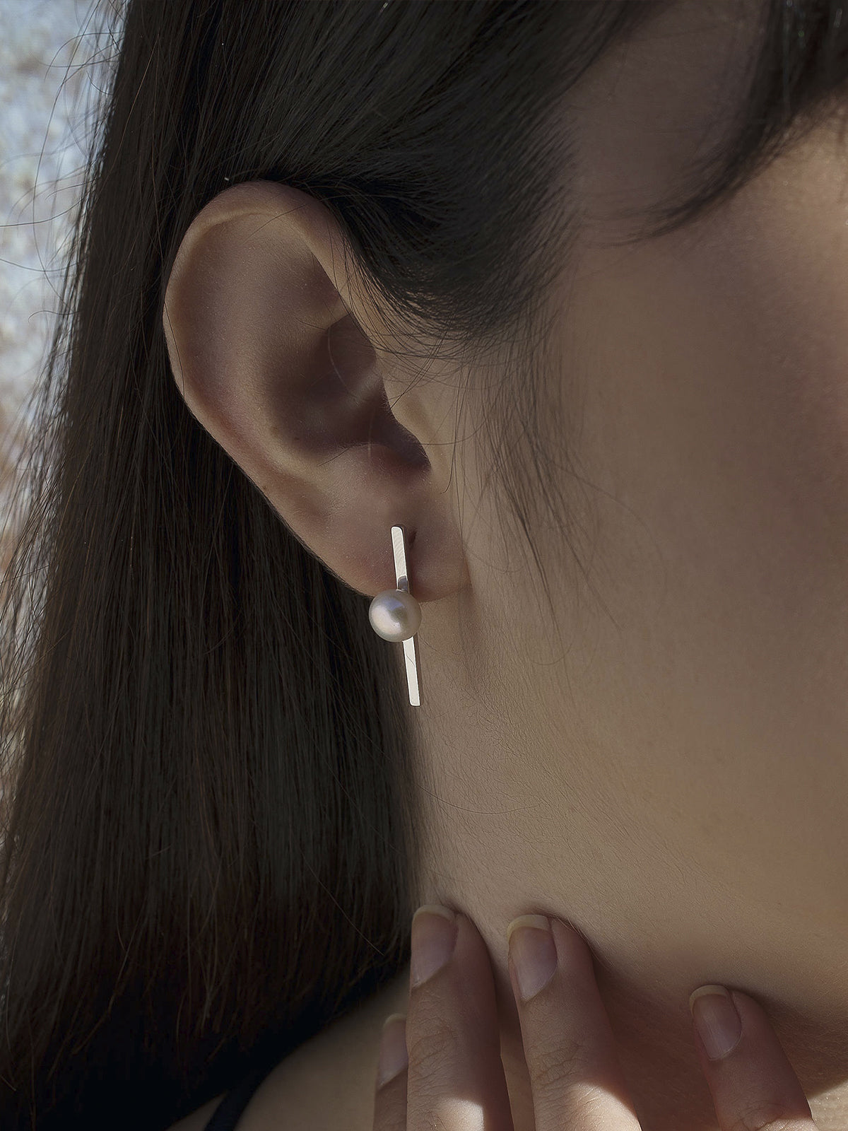 Minimalist design pearl earrings with a central pearl