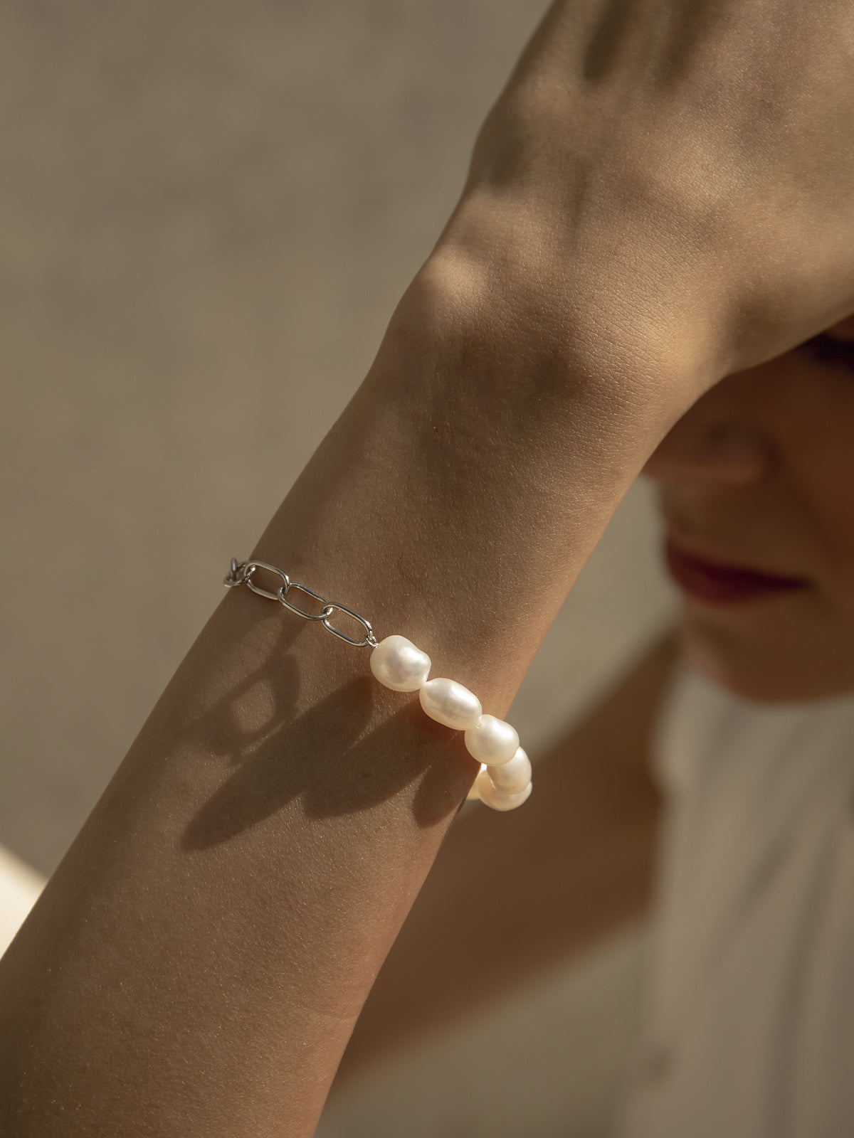 Long pearl earrings with an irregular liquid design.