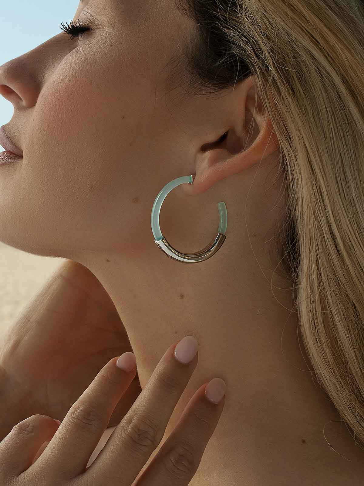 Hoop earrings, resin design in a blue tone and a central smooth silver band.