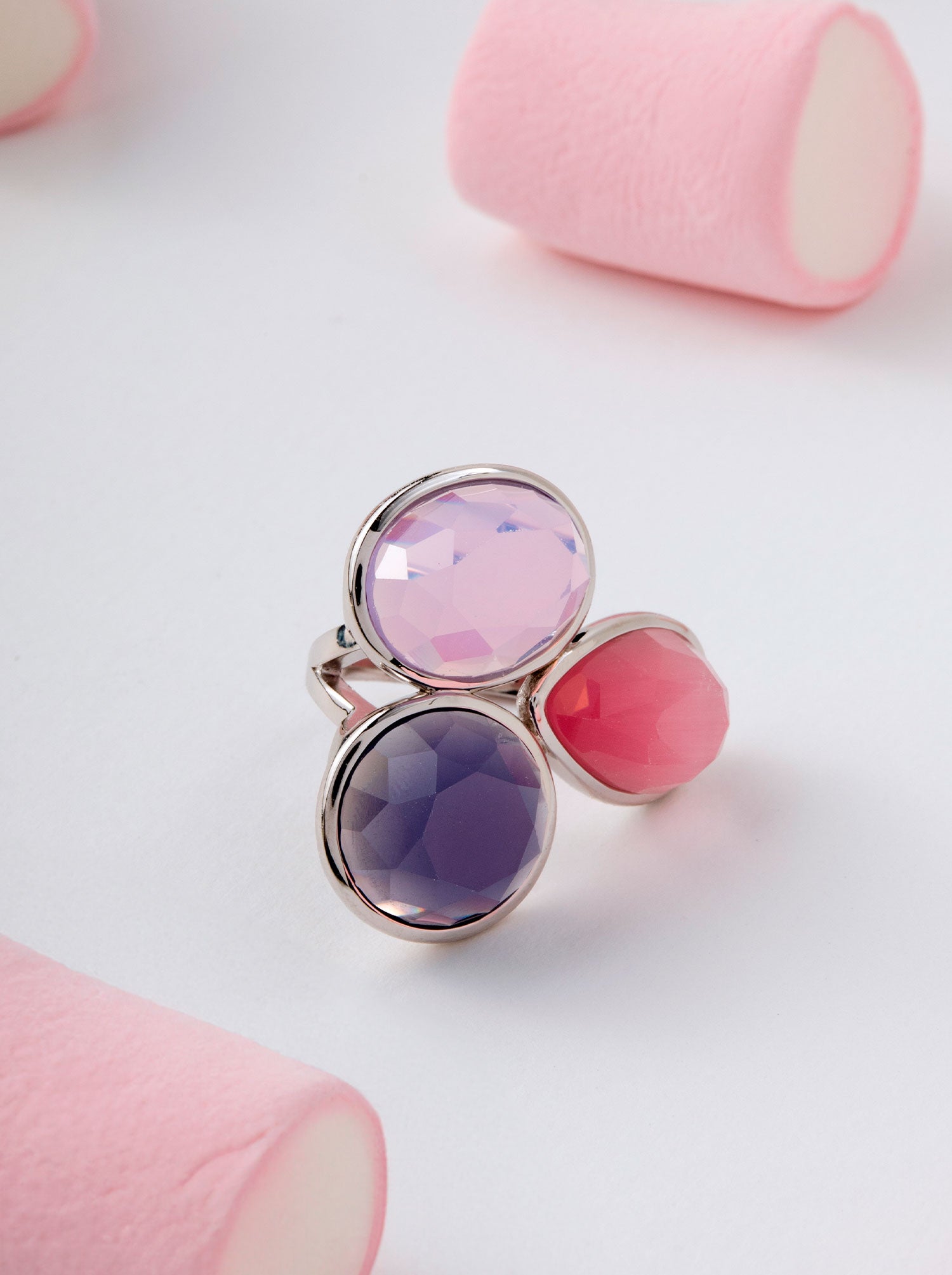 Silver ring with three faceted stones in shades of violet and pink