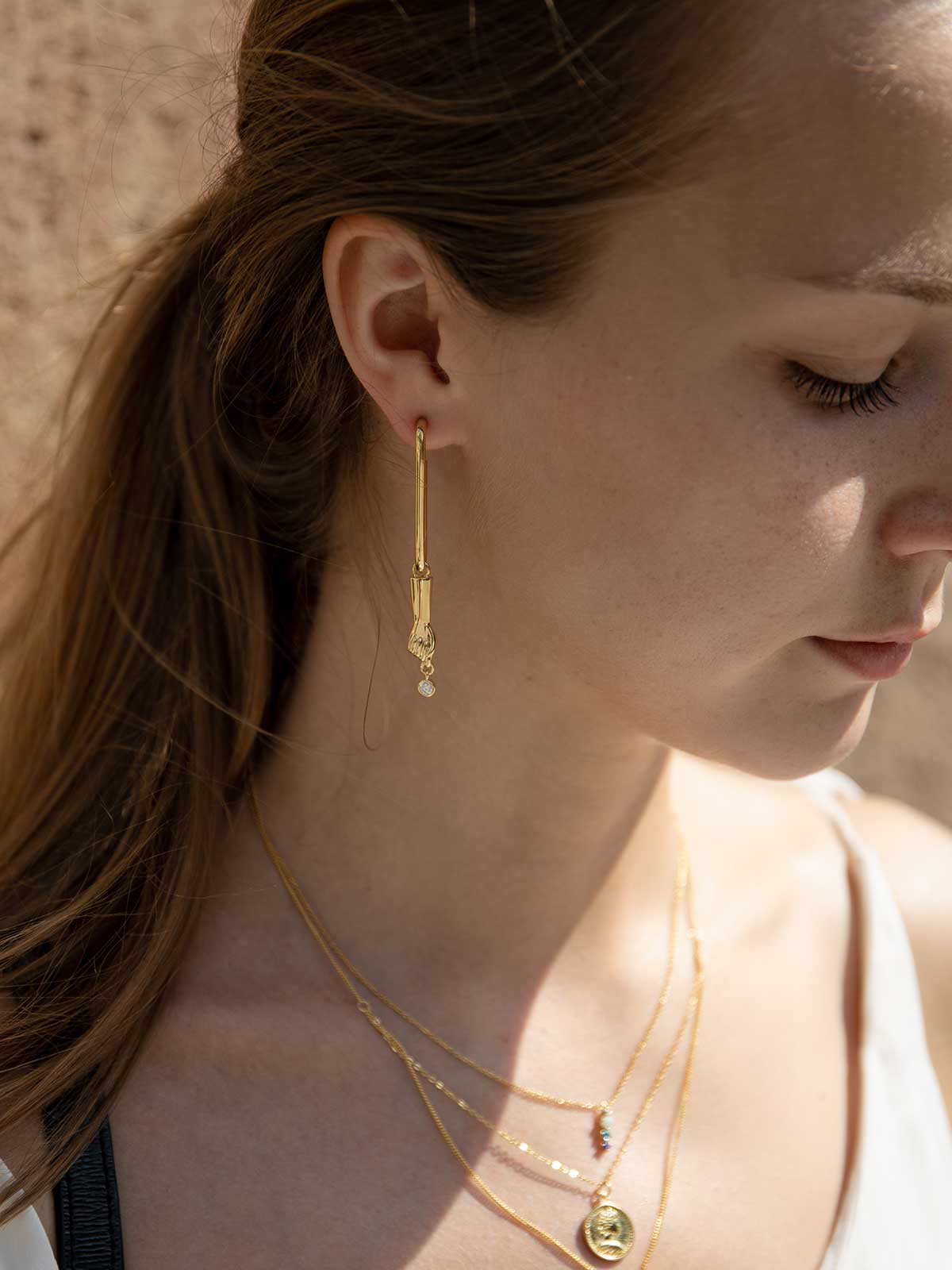 Pendientes largos de plata finos estilo aro diseño de mano y circonita baño en oro
