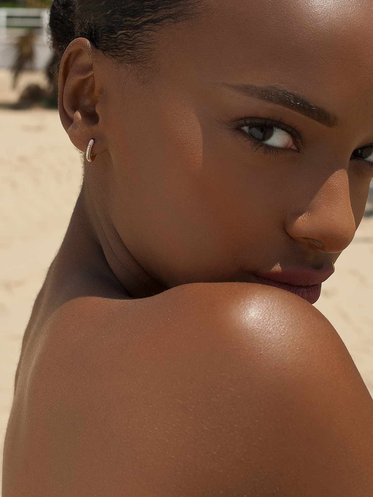 Petites boucles d'oreilles créoles en émail rose avec une ligne centrale de zircone cubique.