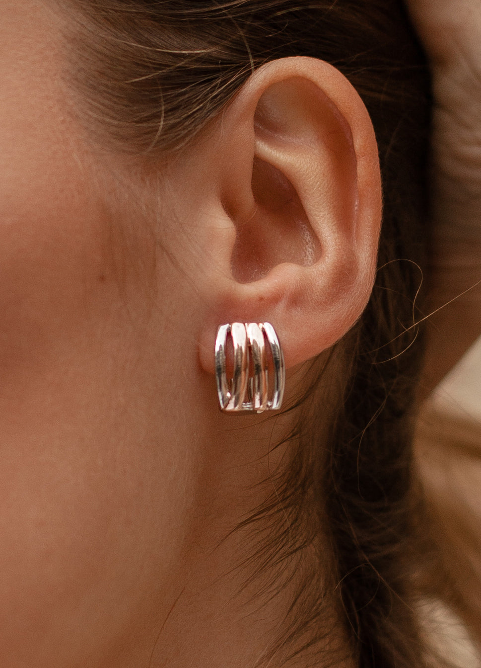 Omega clasp earrings with two-tone track design