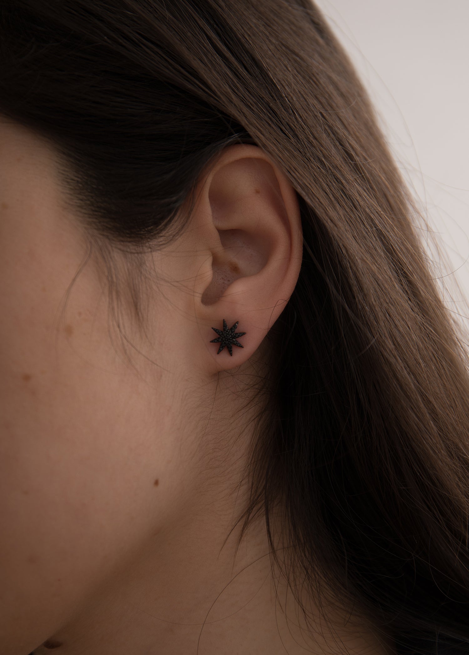 Small sparkling ruthenium-plated silver earrings with a polar star motif