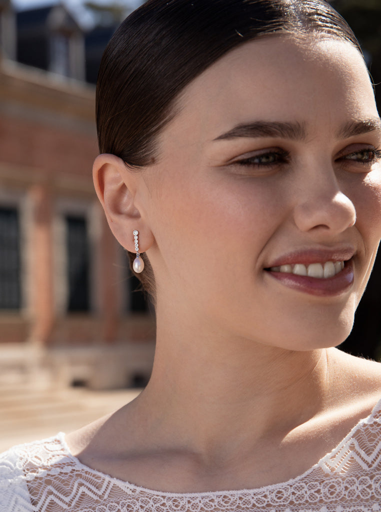 Silver earrings with freshwater pearl pendant design and moving cubic zirconia.