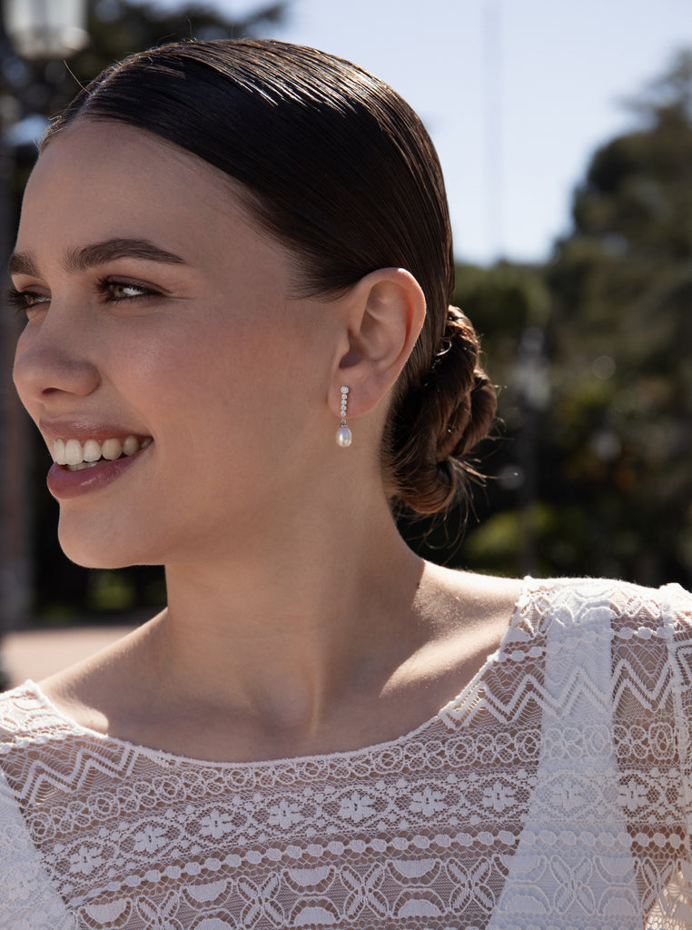 Silver earrings with freshwater pearl pendant design and moving cubic zirconia.