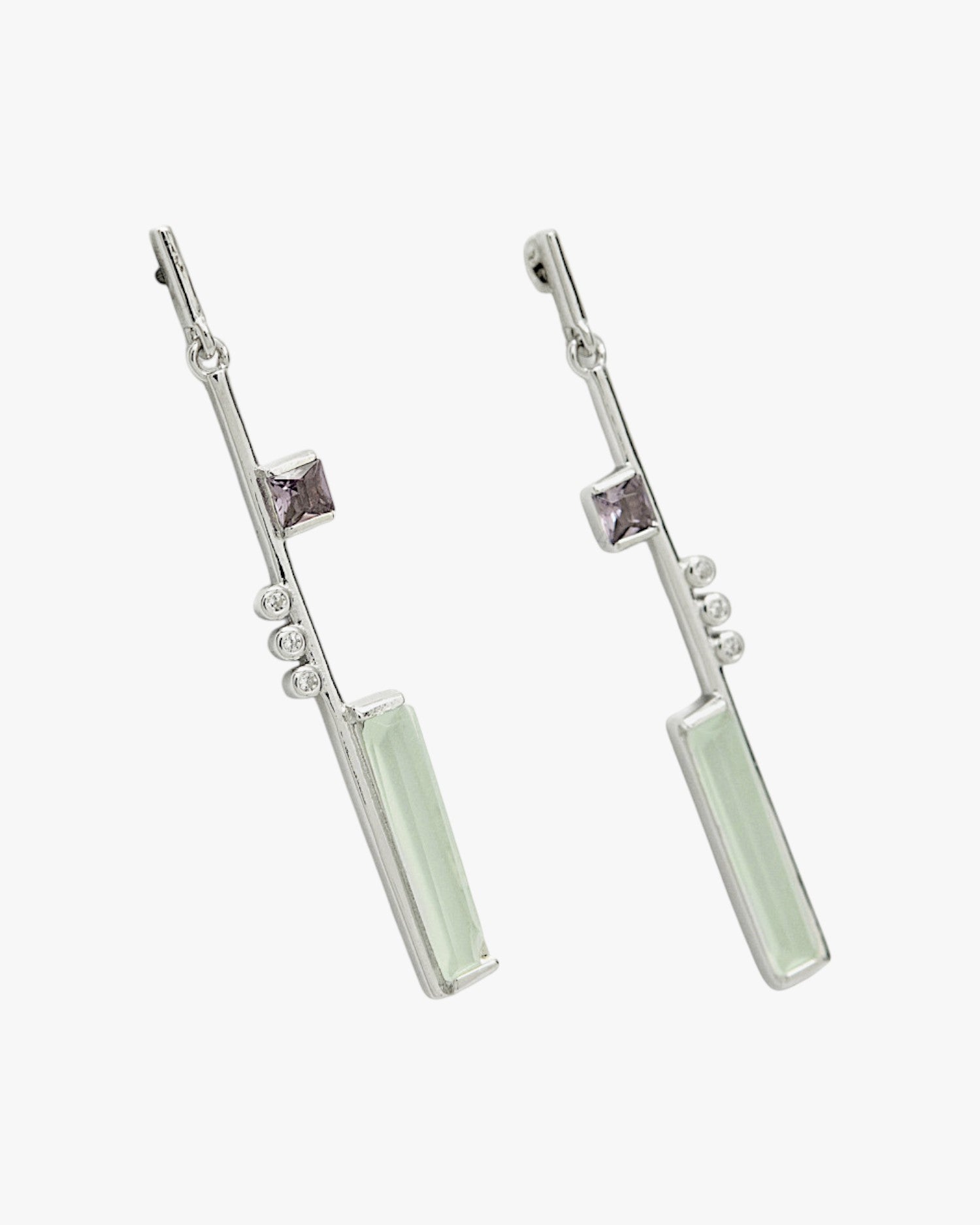 Longues et fines boucles d'oreilles en argent, au design asymétrique et ornées de pierres précieuses.
