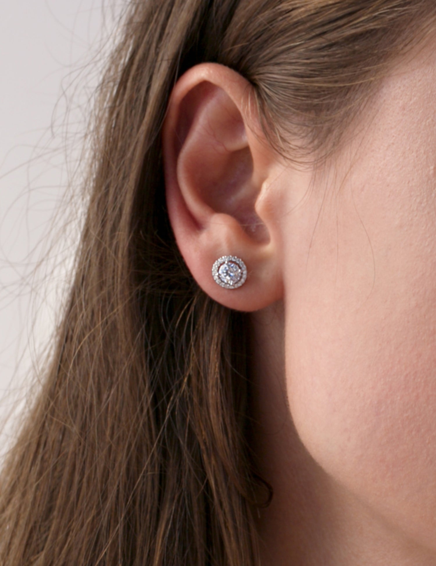 Small, shiny silver earrings with a round motif and cubic zirconia