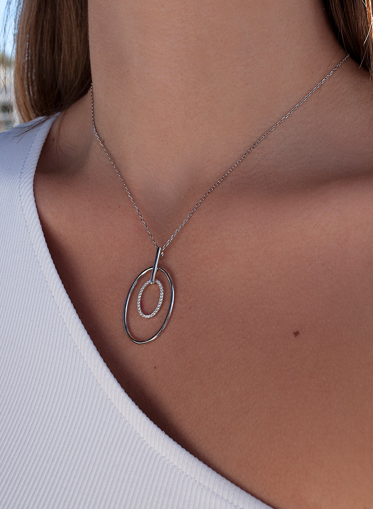 Shiny silver pendant with double circular motif