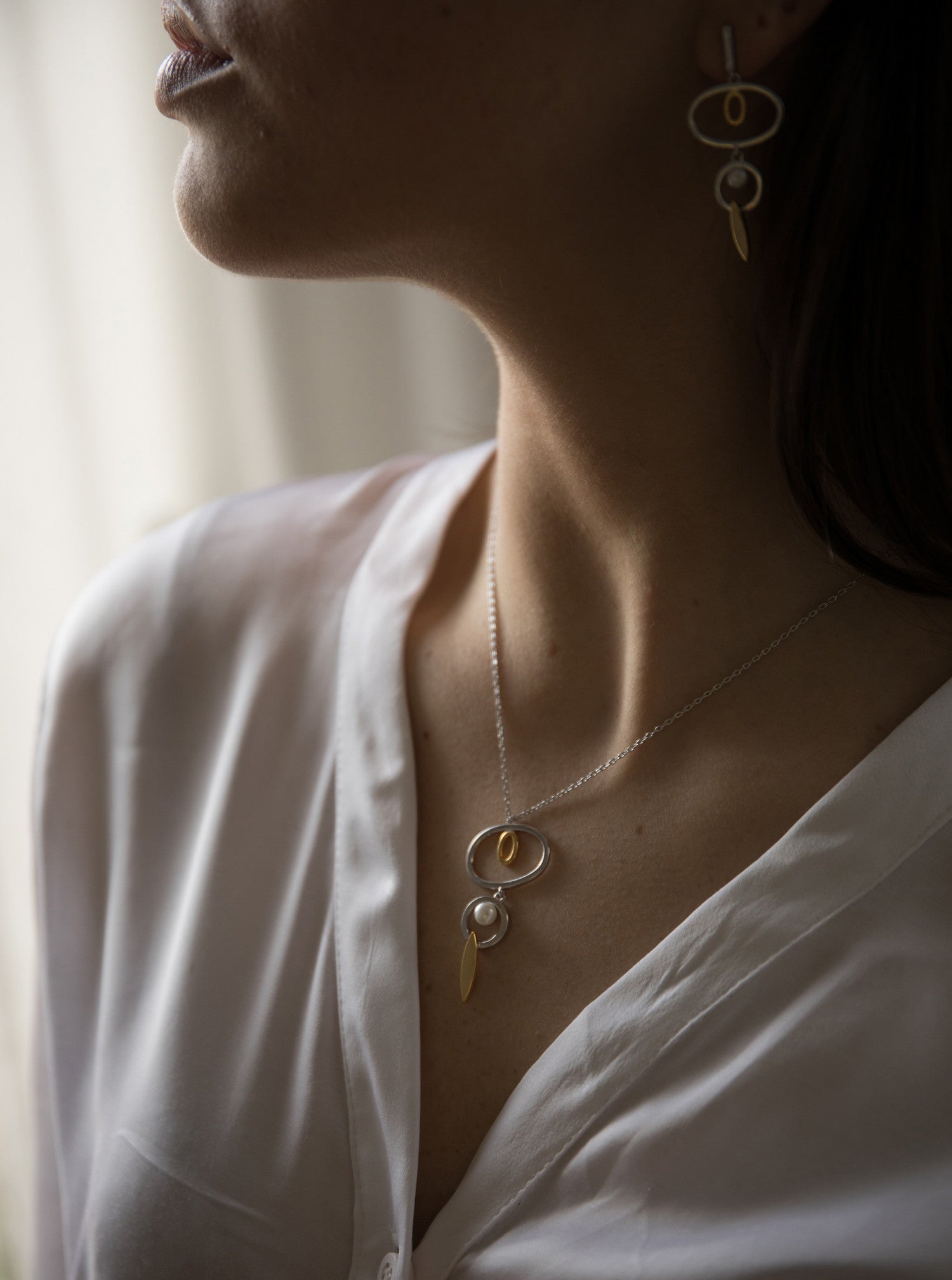 Pendientes largos de plata diseño bicolor con círculos y detalle de perla