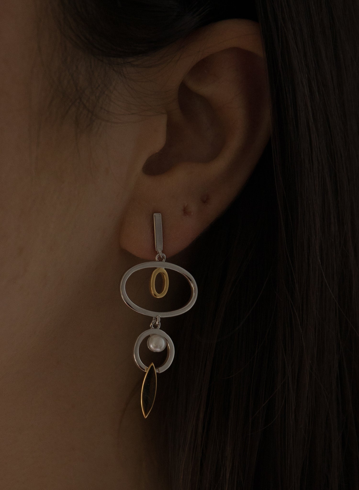 Longues boucles d'oreilles argentées, modèle bicolore orné de cercles et de perles.