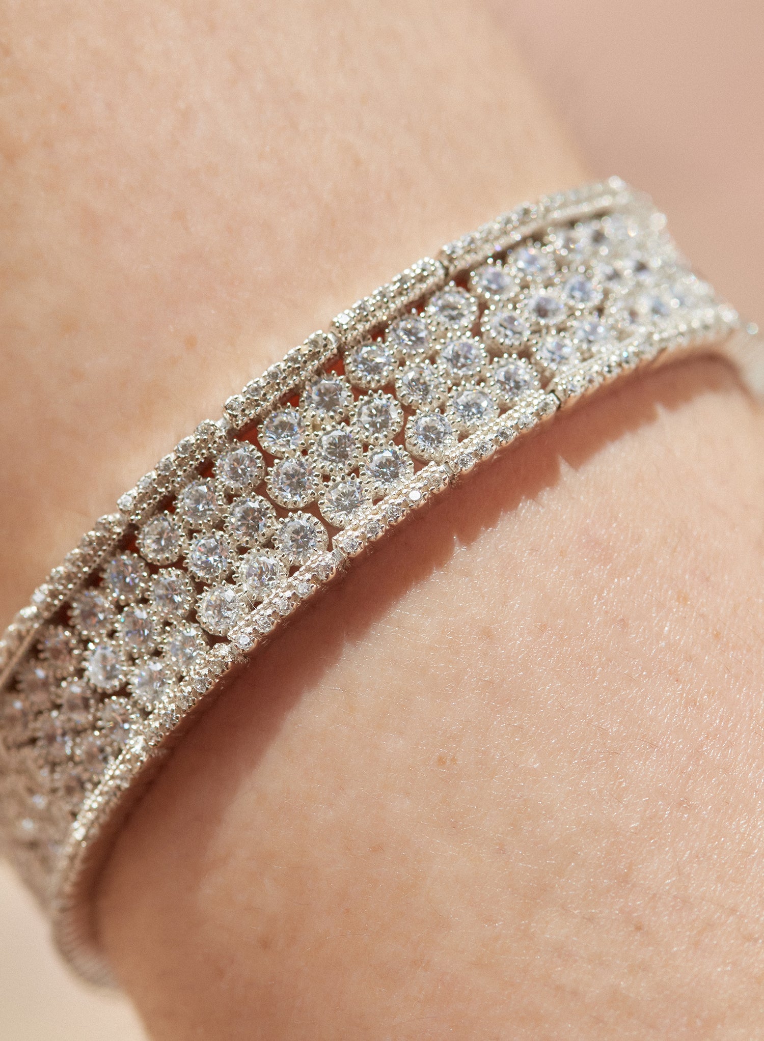 Silver riviere bracelet with multiple rails of round white adamantine quartz and cubic zirconia detail on the sides