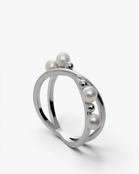 Bagues délicates ornées d'un motif en croix, de perles et de sphères.