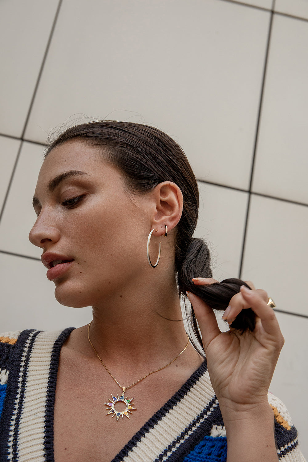 Small hoop earrings in silver and black enamel with a line of central cubic zirconia.