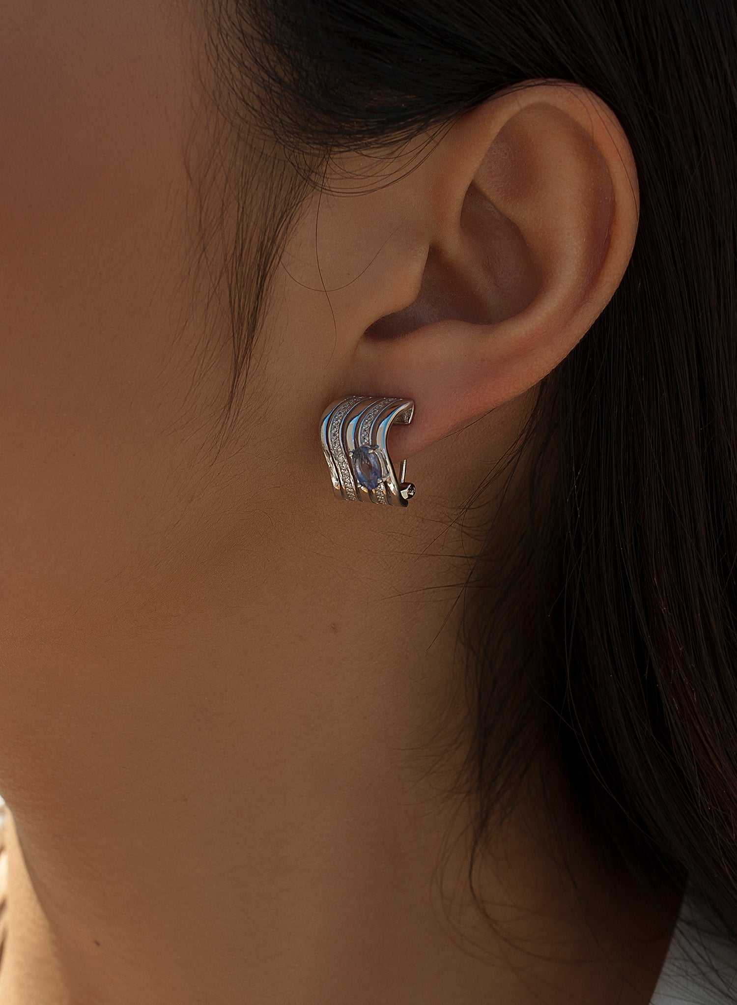 Omega clasp earrings with wave design and central gem
