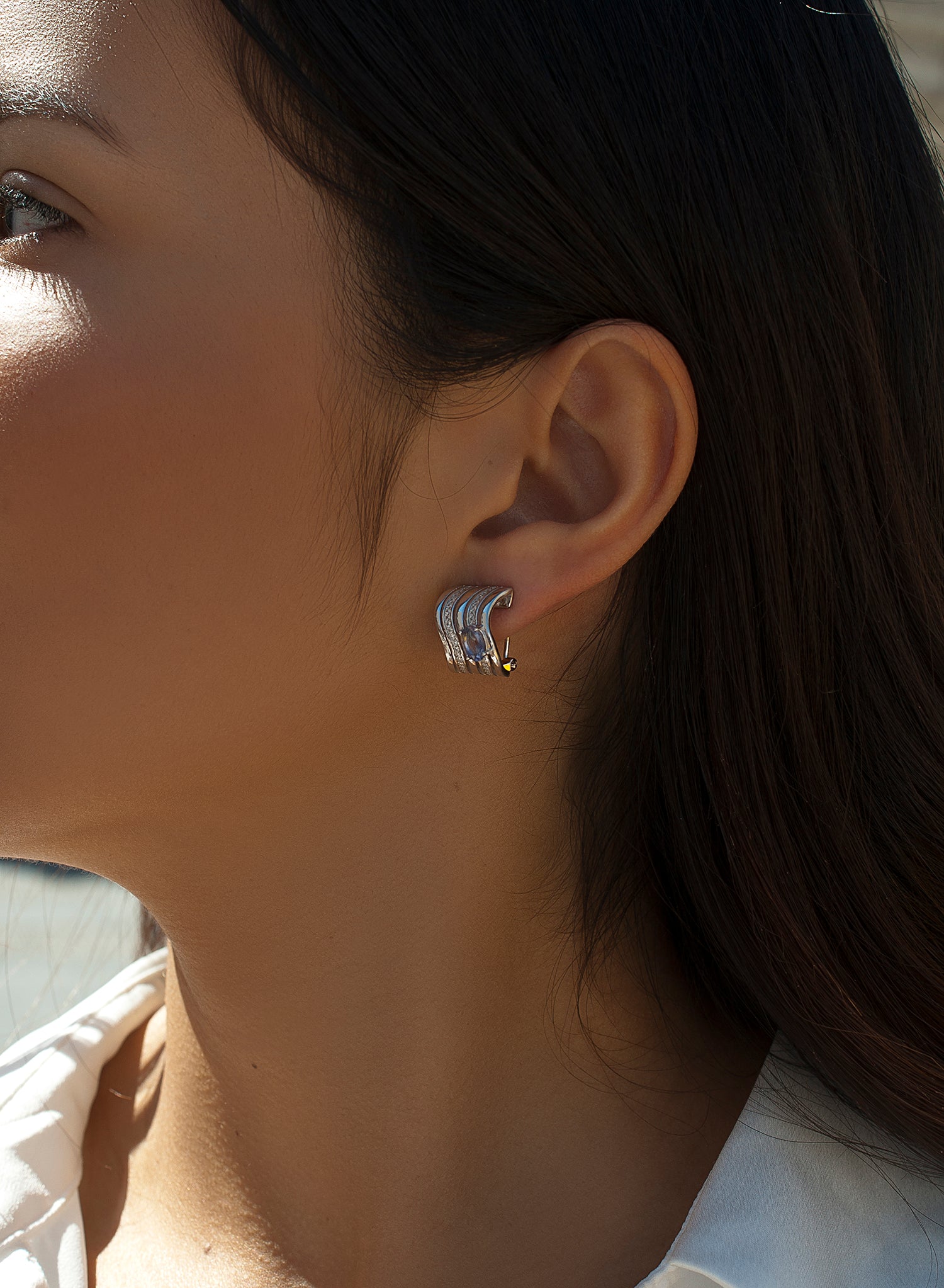 Omega clasp earrings with wave design and central gem