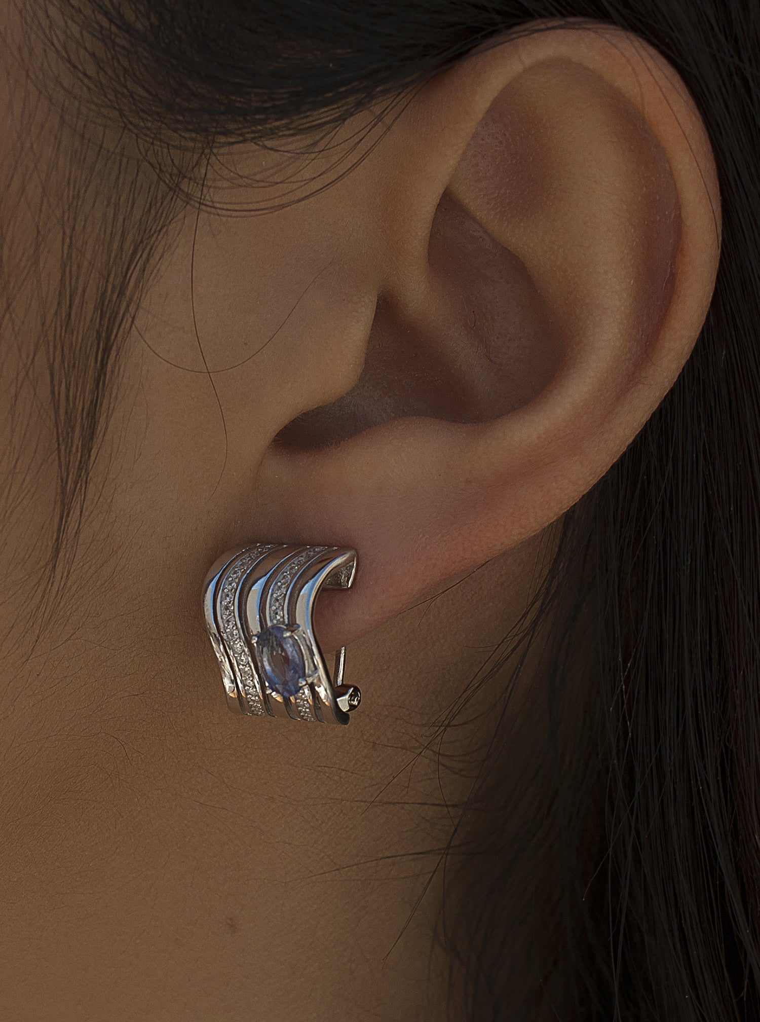 Omega clasp earrings with wave design and central gem