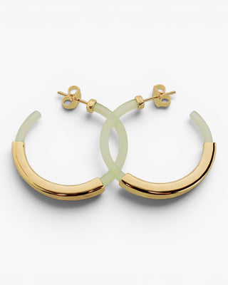 Boucles d'oreilles créoles, modèle en résine de couleur verte avec un anneau central lisse en argent.