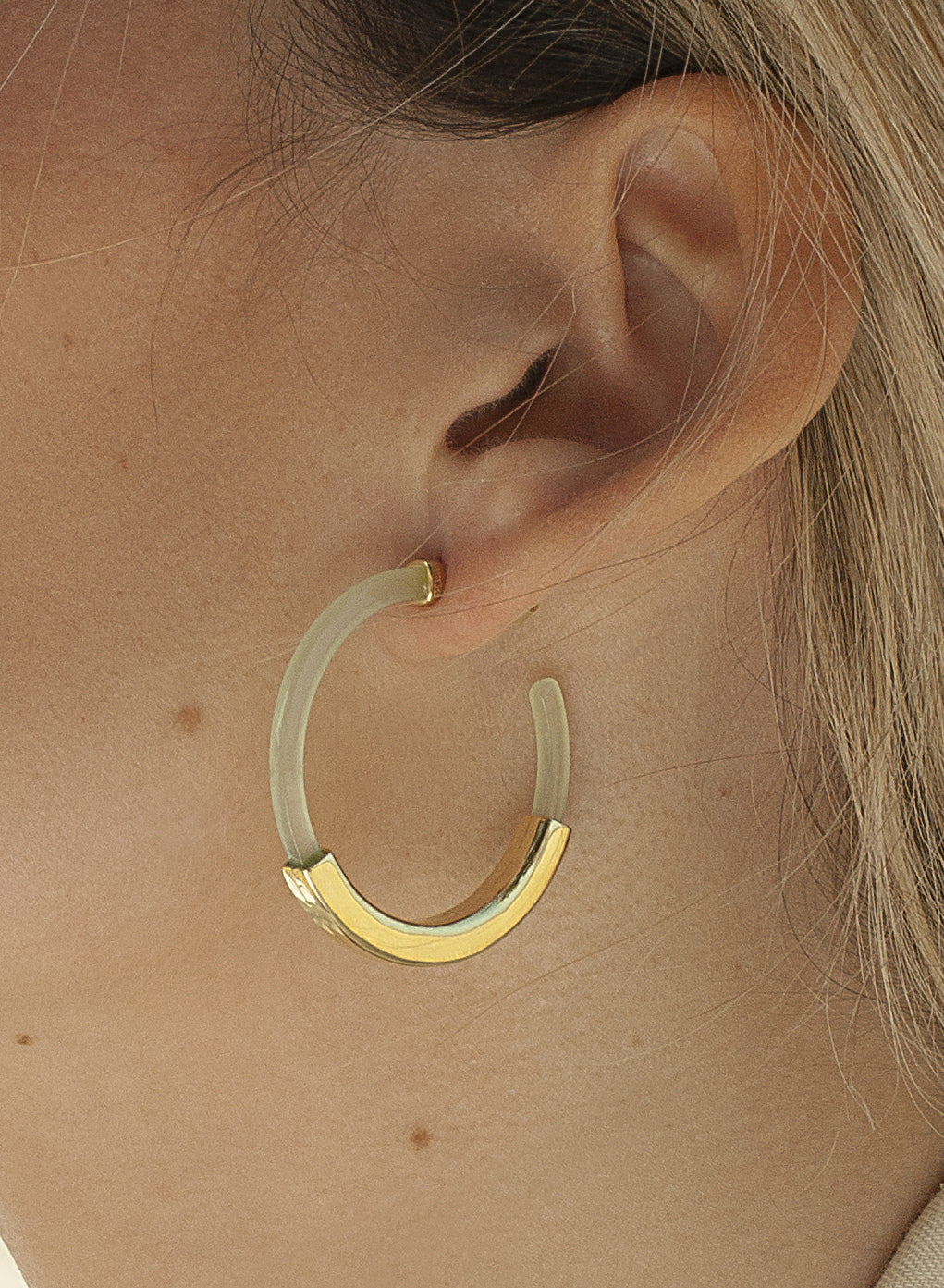 Boucles d'oreilles créoles, modèle en résine de couleur verte avec un anneau central lisse en argent.