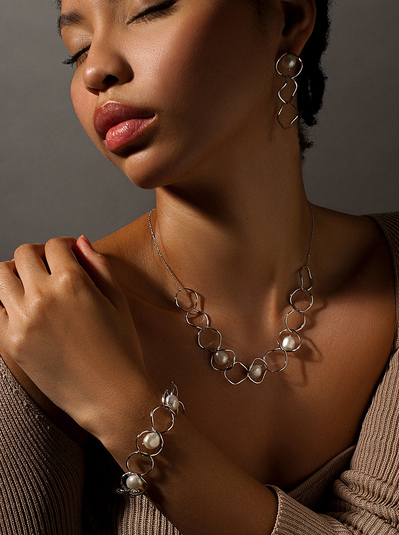 Pendientes largos detalle perla diseño de tres aros