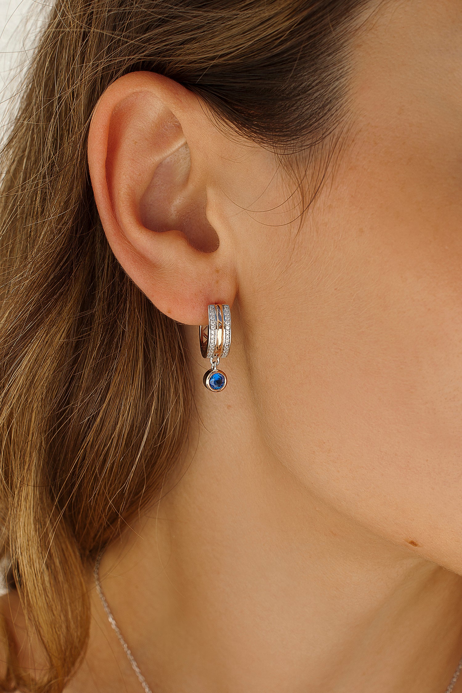 Small hoop earrings with blue charm design and cubic zirconia