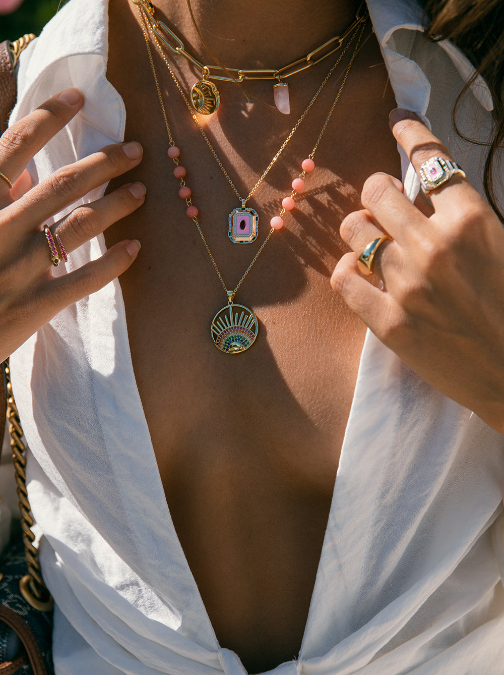 Collier orné d'un médaillon représentant un demi-arc-en-ciel et des rayons de soleil.