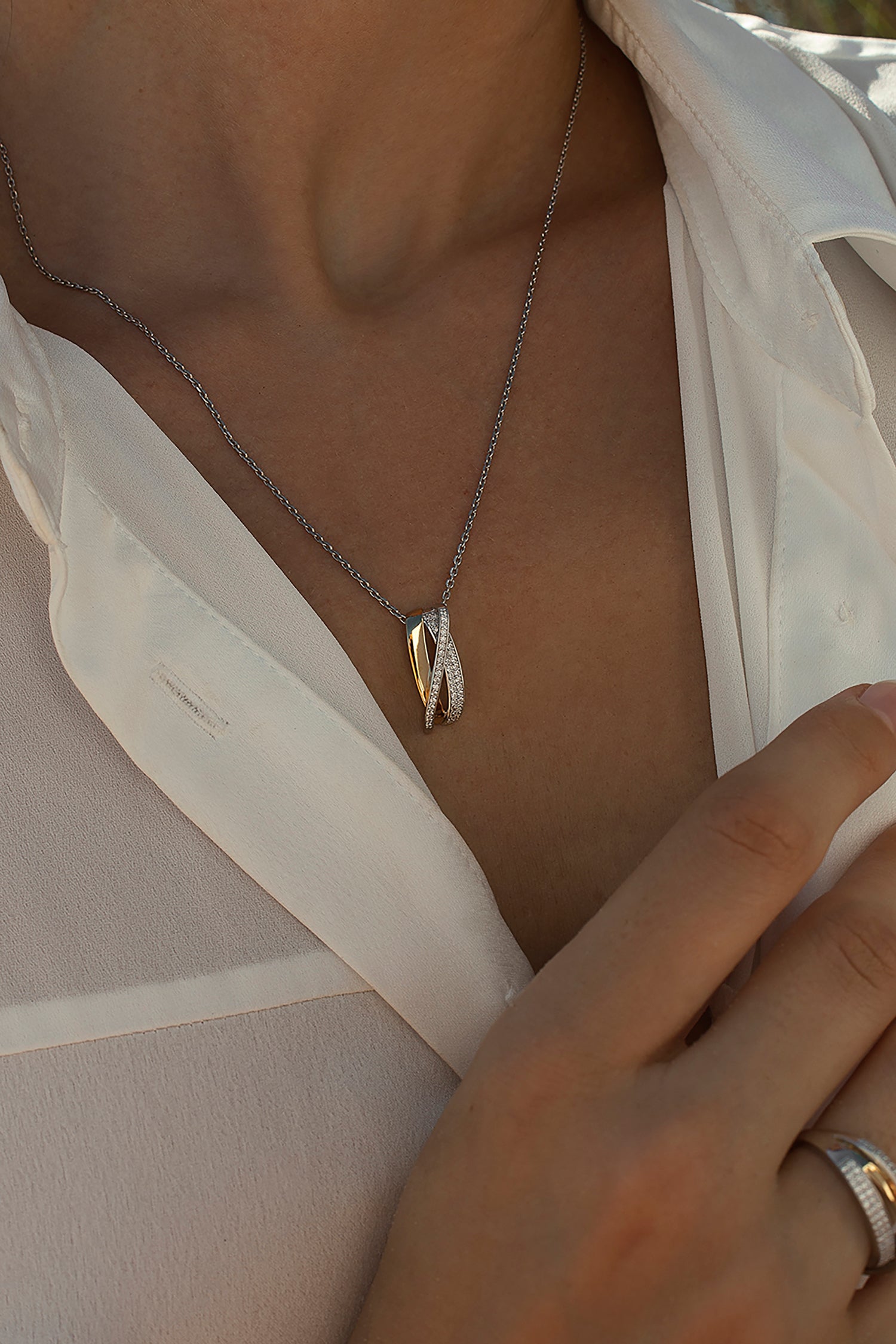 Bicolor pendant formed by a crossed zirconia rail