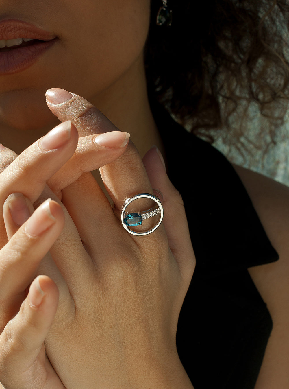 Circular design rings with a blue-toned gemstone