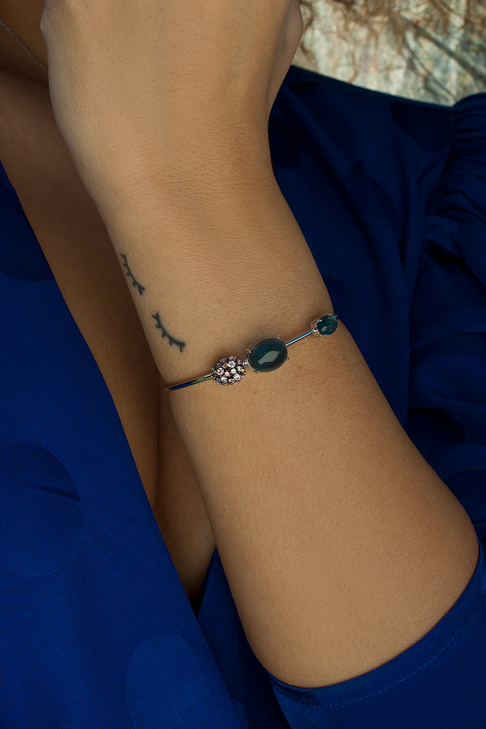 Pulsera esclava con piedras en tonos azules y motivo con circonitas de colores