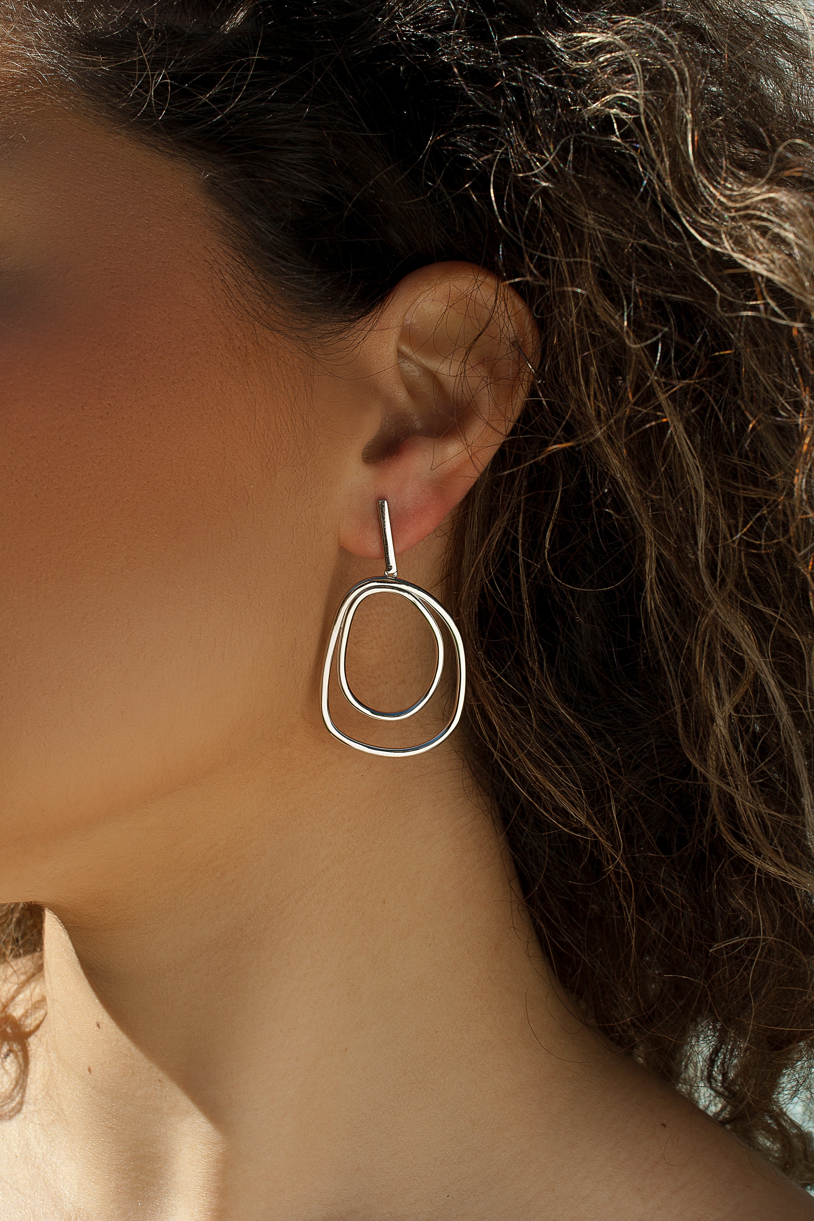 Large hoop earrings with irregular design in plain silver