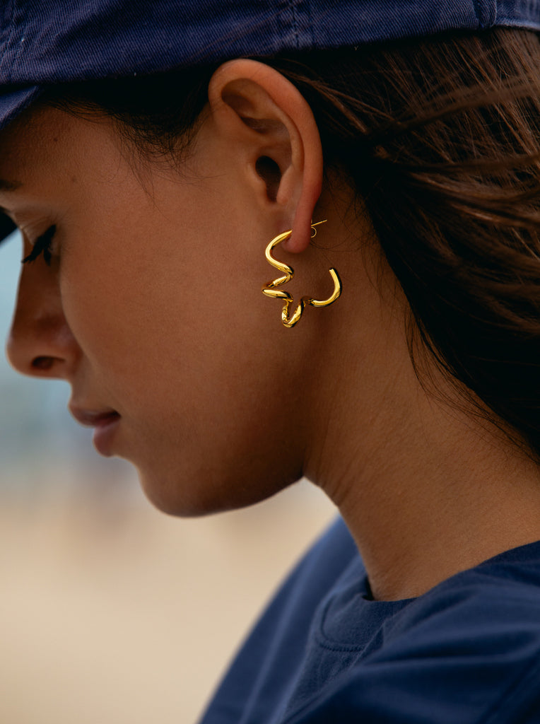 Boucles d'oreilles créoles originales en argent plaqué or avec un motif en spirale