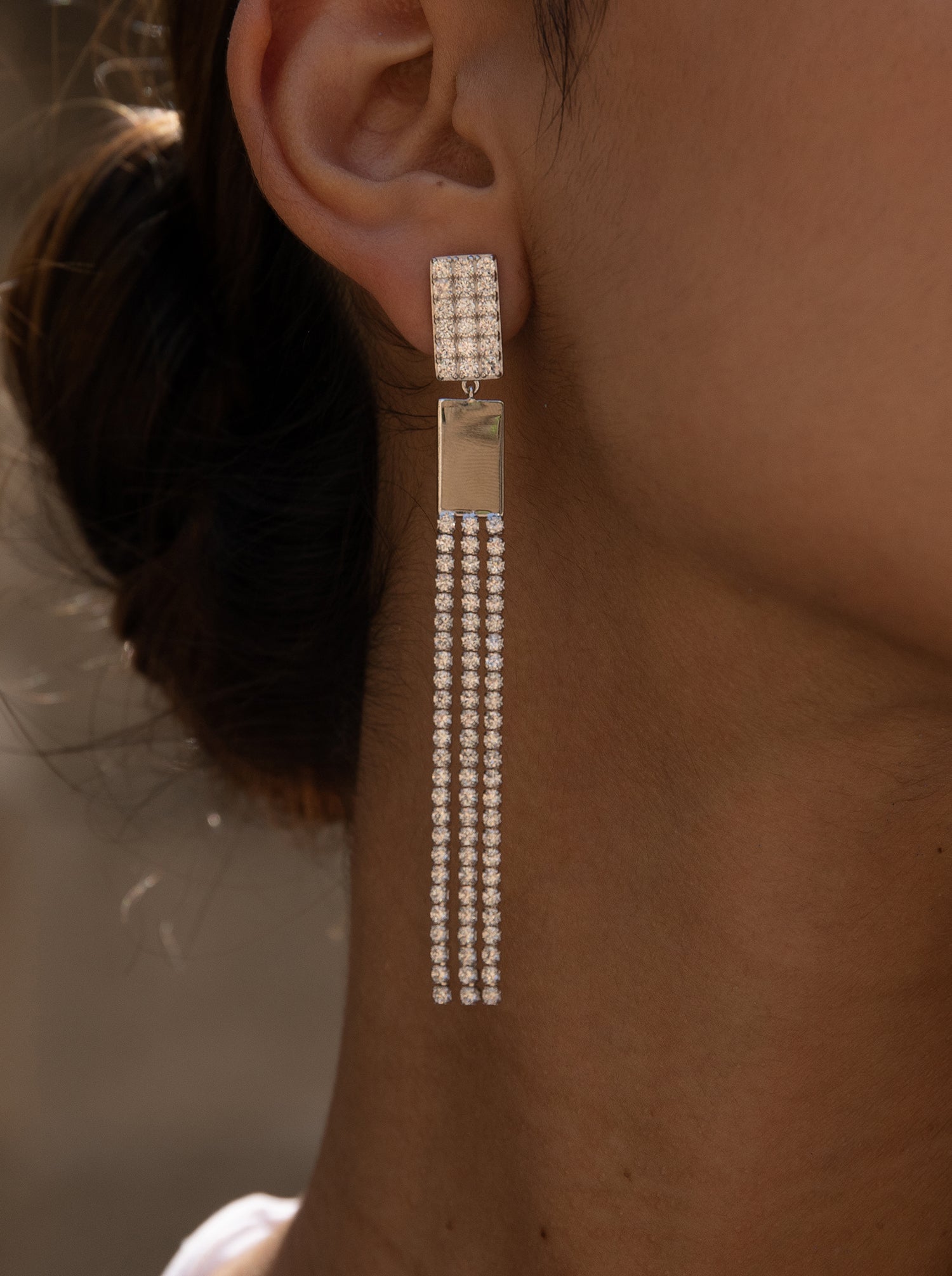 Long silver earrings with three strands of cubic zirconia