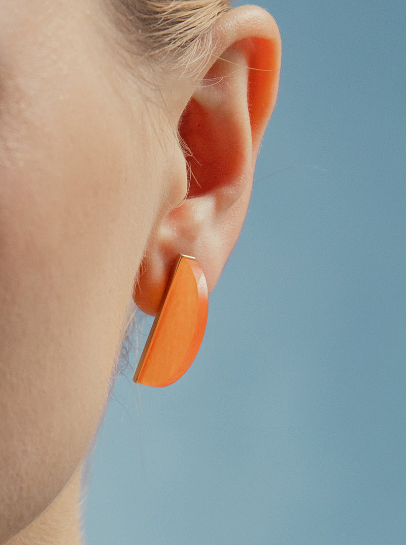 Earrings in orange-toned stone in the shape of a half circle